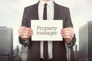 Property manager on paper what businessman is holding on cityscape background, represent a propert manager at The Realty Medics