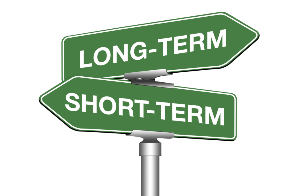 Two green signs that are pointing opposite directions. One says Long-Term and the other says Short-Term.