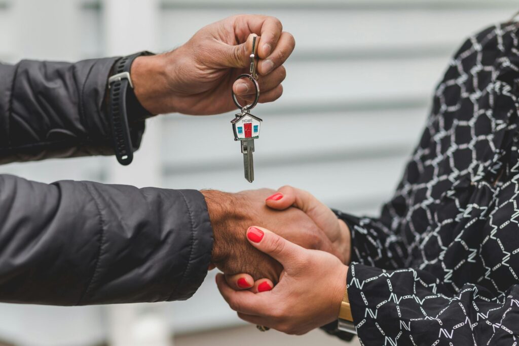 Hands exchange keys in a gesture of landlord-tenant agreement, symbolizing fulfillment of Orlando tenant rights.